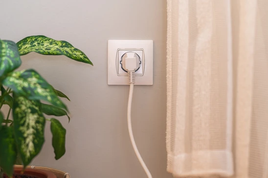 Incendie &eacute;lectrique domestique avec c&acirc;ble d'alimentation en feu connect&eacute; &agrave; une prise murale