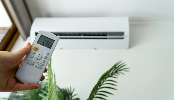 Jeune Femme Heureuse Tenant Une T&eacute;l&eacute;commande Se D&eacute;tendre Sous Le Climatiseur